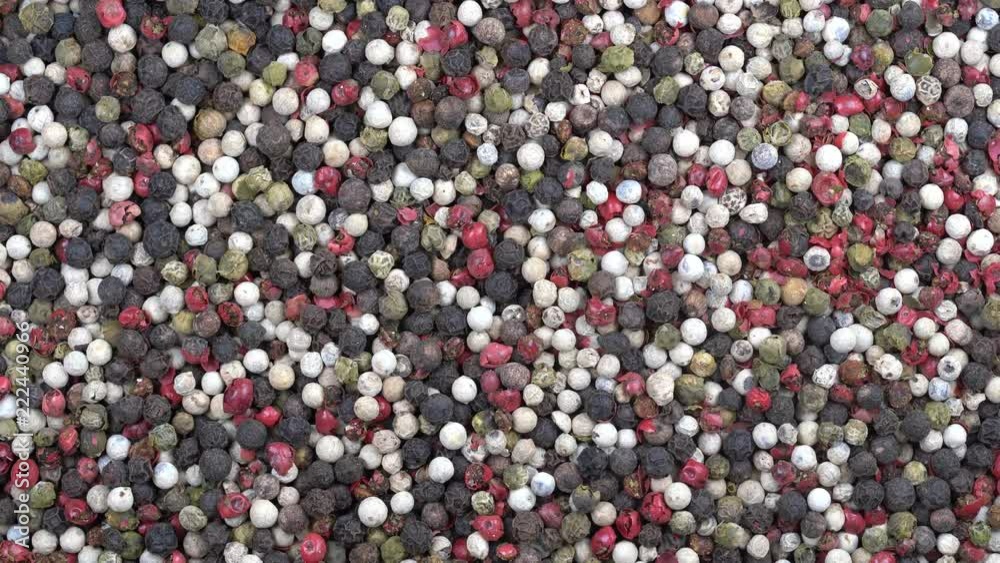 Black, white and red dry pepper background, rotation. Front of the camera rotates plate with black, white and red pepper, close up, top view, macro peppercorns Black, white and red dry pepper background, rotation. Front of the camera rotates plate with black, white and red pepper, close up, top view, macro peppercorns