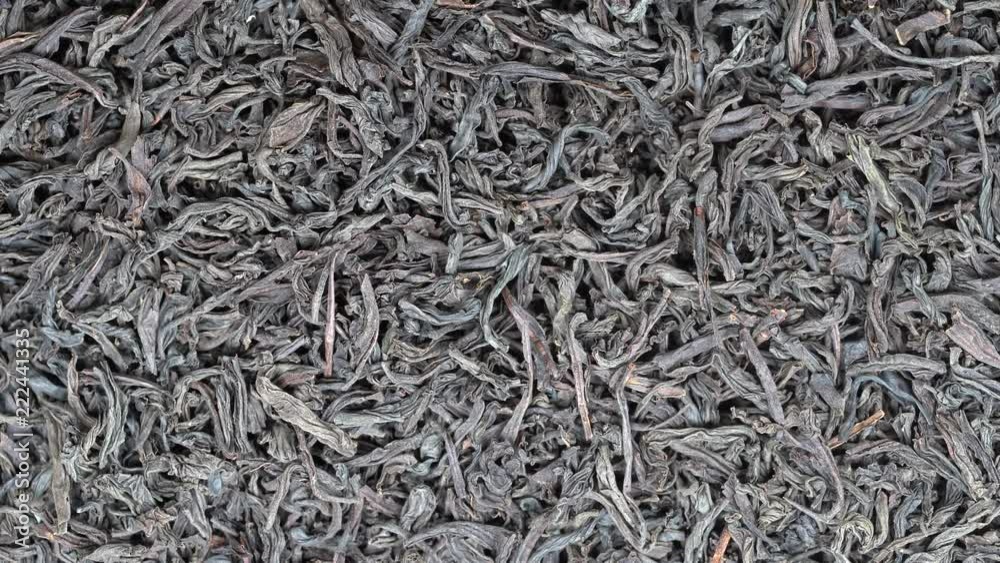Large leaves of black tea background, close up. Loop rotation. Front of the camera rotates plate with black tea, macro Large leaves of black tea background, close up. Loop rotation. Front of the camera rotates plate with black tea, macro