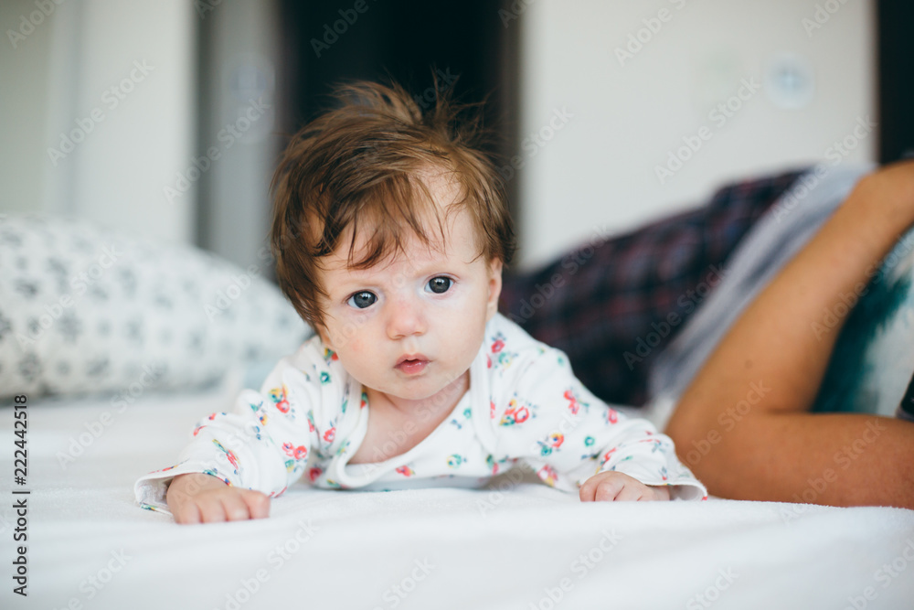 Portrait of cute baby girl lying on white bedding Portrait of cute baby girl lying on white bedding