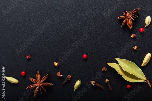 Food background close up various exotic spieces on black slate board