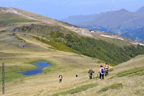 Россия, Кавказ, Архыз. Туристы на плато Габулу в солнечную погоду спускаются к небольшому озеру