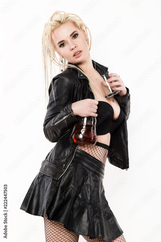 sexy woman with dreadlocks holding bottle adn glass of whiskey on a light background sexy woman with dreadlocks holding bottle adn glass of whiskey on a light background