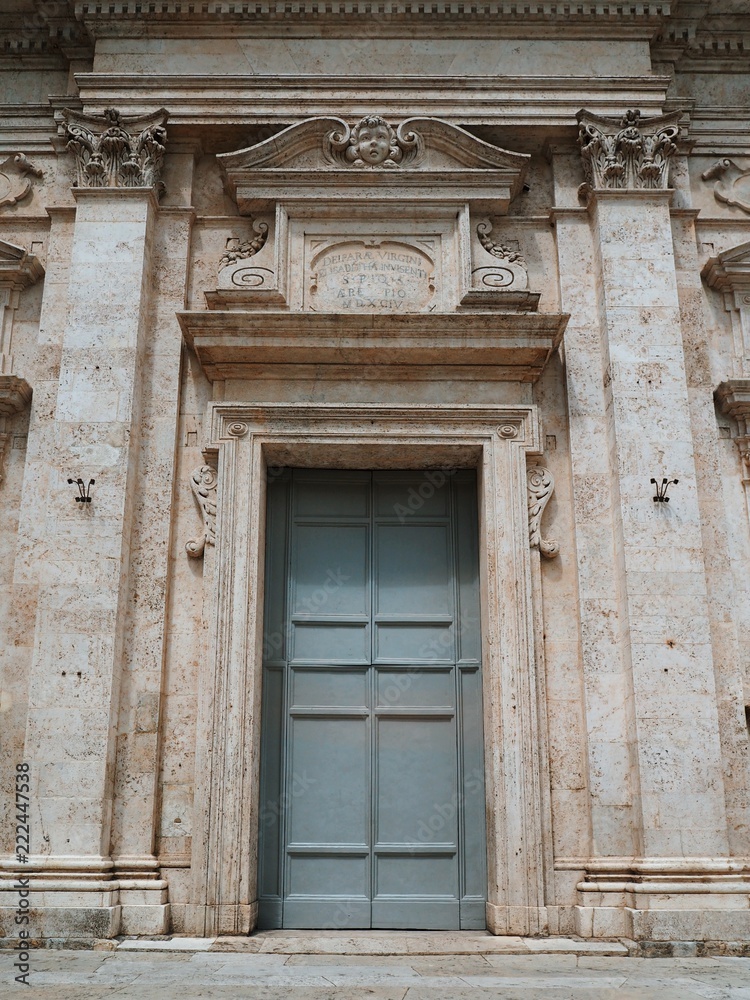 One of the many cathedrals in Siena, Tuscany, with a beautiful blue door, sculptures