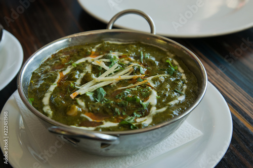 Indian vegetarian food palak paneer on restaurant table, closeup.