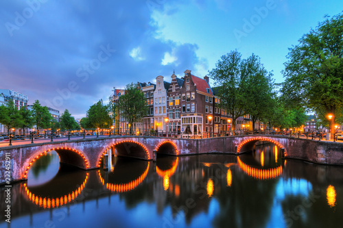 Beautiful cityscape of the famous canals of Amsterdam, the Netherlands, at night with bridges at the Emperor's canal (keizersgracht) and Leidse canal (Leidsegracht) photo