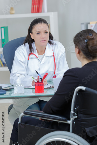 female doctor talking to her patient on wheelchair