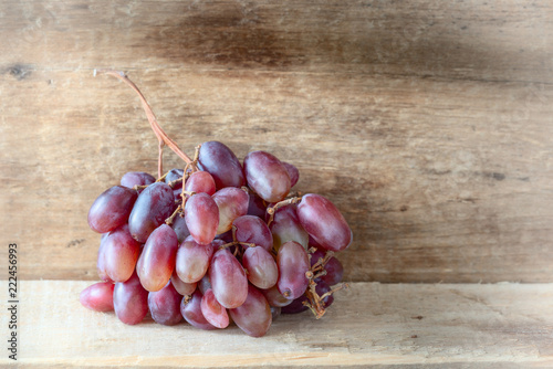 Fresh colorful grapes on a wooden plank, under the soft morning light
