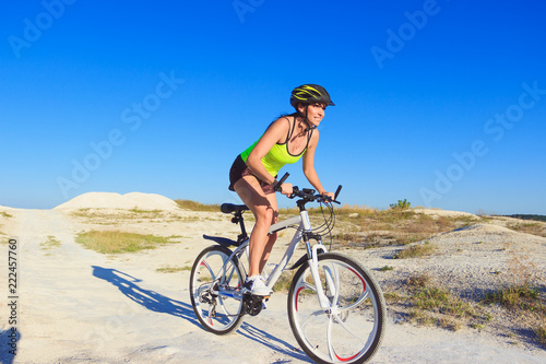 Young beautiful woman with a sport bike, soft focus background