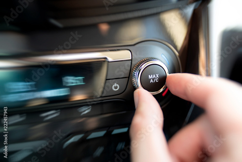 Man turning on car air conditioning system
