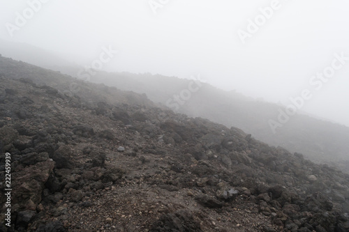 The dark land of the slopes of the mount Etna. An active volcano in Sicily Etna. People hike up this famous place to see this unusual landscape.