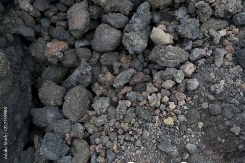 Texture of the dark land of the slopes of the mount Etna. An active volcano in Sicily Etna. People hike up this famous place to see this unusual landscape.