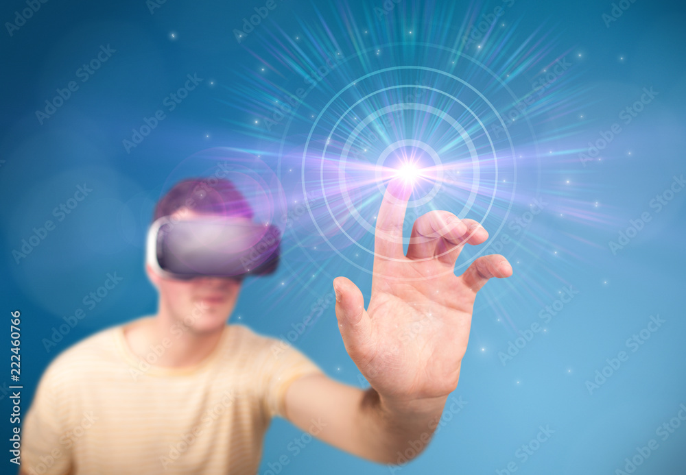 Young impressed man wearing virtual reality goggles with blue circles around his finger Young impressed man wearing virtual reality goggles with blue circles around his finger