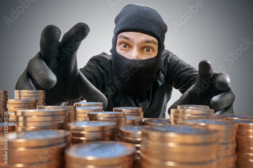 Robber or thief is trying to grab and steal coins.