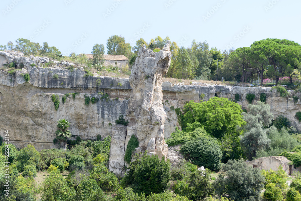An high weird-shaped rock in the center of the archaeological park of the city of Syracuse in Sicily (Italy). In this place the ancient inhabitants used to take out building stone