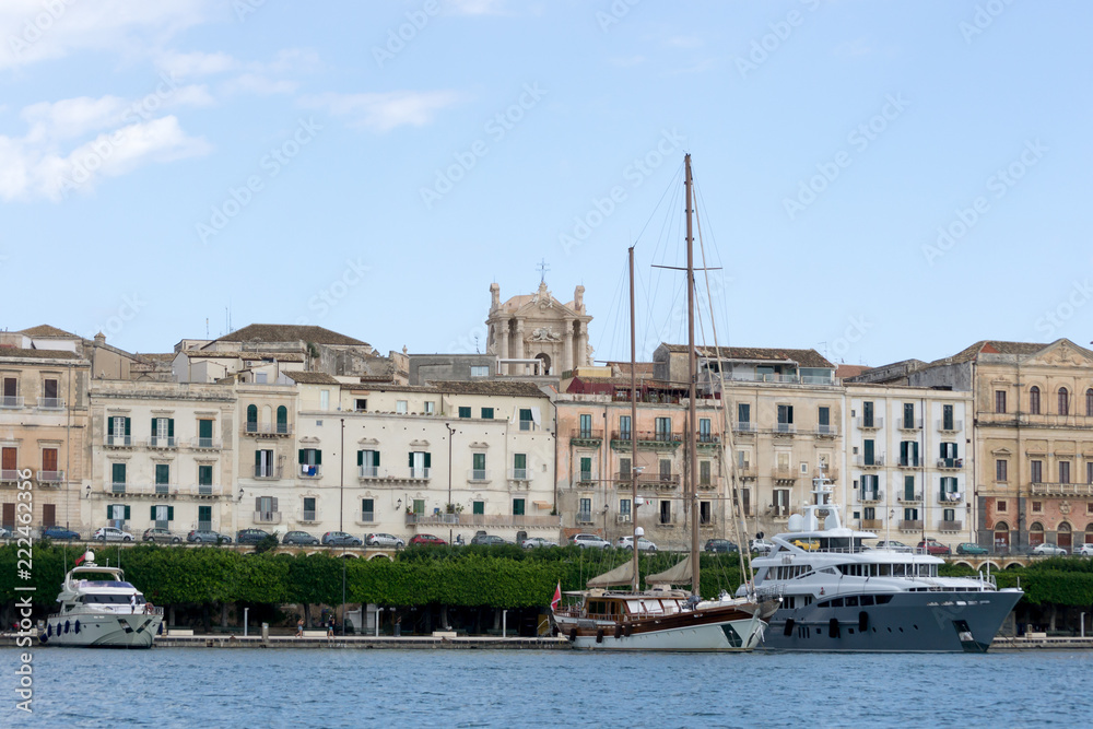 The seafront of the island of Ortigia, in the city of Syracuse, Sicily(Italy). In this shot taken from a boat you can see the new touristic harbor and the city architecture from the nineteenth century