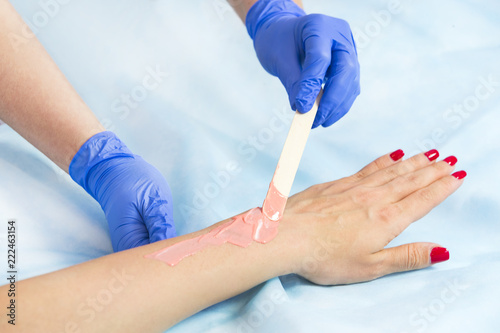 Process depilation female legs and hands in a beauty salon 