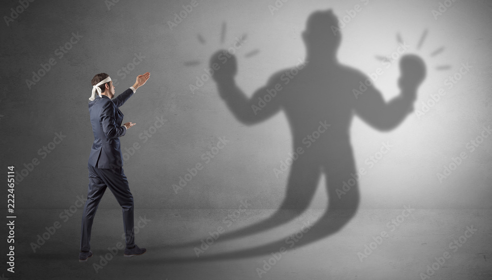 Businessman trying to fight with his unarmed shadow
Businessman trying to fight with his unarmed shadow