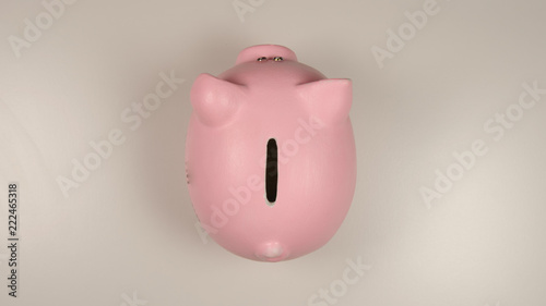 TOP VIEW: Pink pig money box on a white table