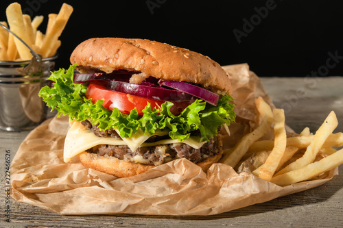 Burger with potatoes. Served on a wooden background photo