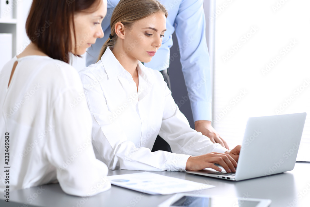 Group of business people using laptop computer in office. Meeting and teamwork concept Group of business people using laptop computer in office. Meeting and teamwork concept