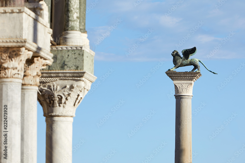 Obraz premium San Marco winged Lion statue on column, symbol of Venice in a sunny day, blue sky in Italy