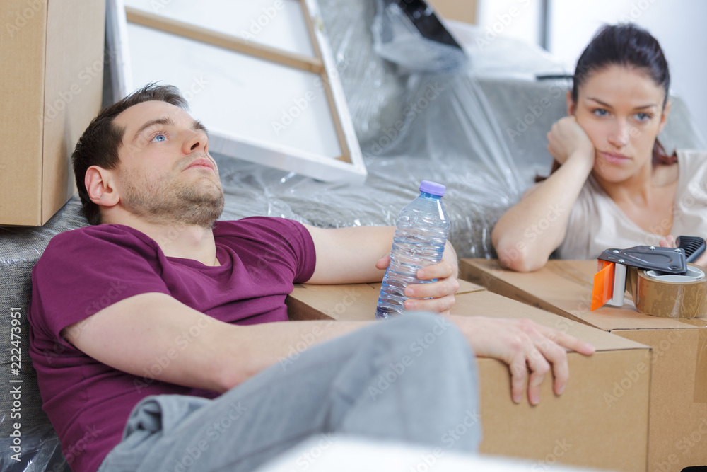 miserable couple sat amongst cardboard boxes miserable couple sat amongst cardboard boxes