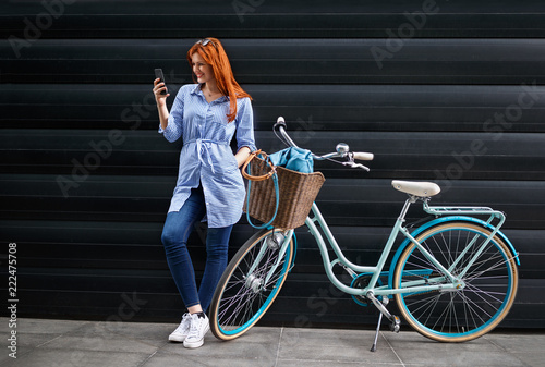 Female looking on cell phone next to bike