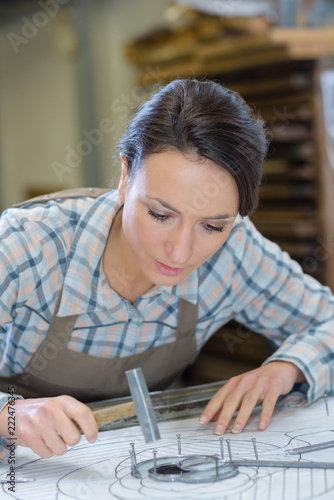 Artist hammering nails into work