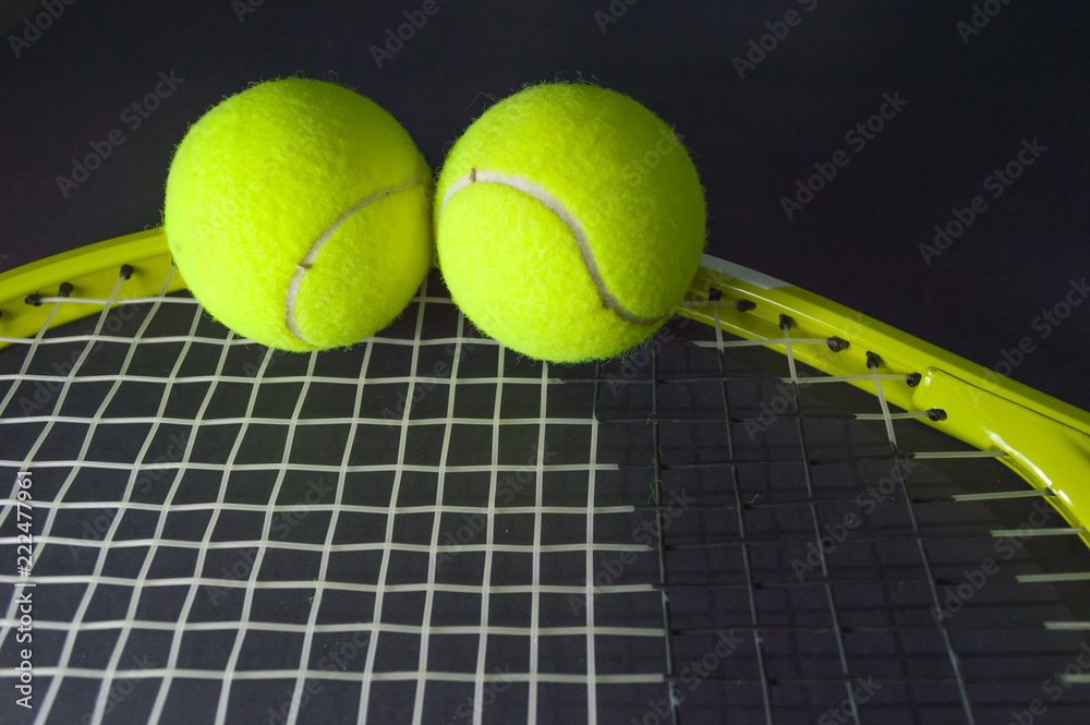 green tennis racket with  tennis balls in green color, isolated on black background, lighting detail sport concept