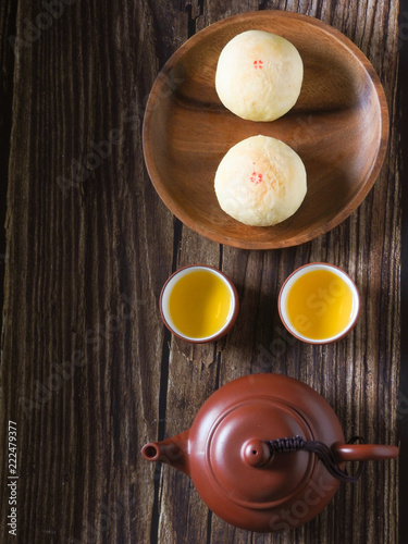 Mid-autumn festival is a traditional festival of East Asian culture and folk. Top view of mung bean pastry and Oolong tea on wooden background. With copy space.  Flat lay.  Taiwan food.