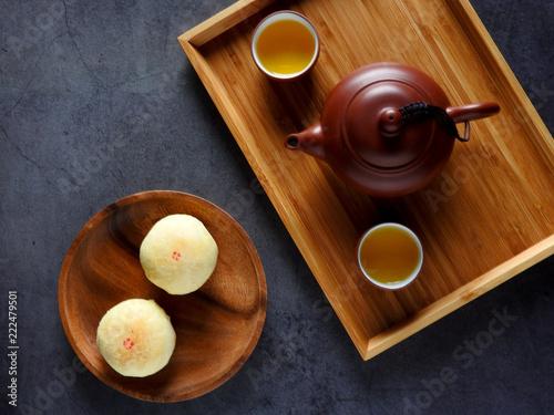 Mid-autumn festival is a traditional festival of East Asian culture and folk. Top view of yolk pastry, mung bean pastry, Oolong tea on black background. With copy space.  Flat lay.  Taiwan food.