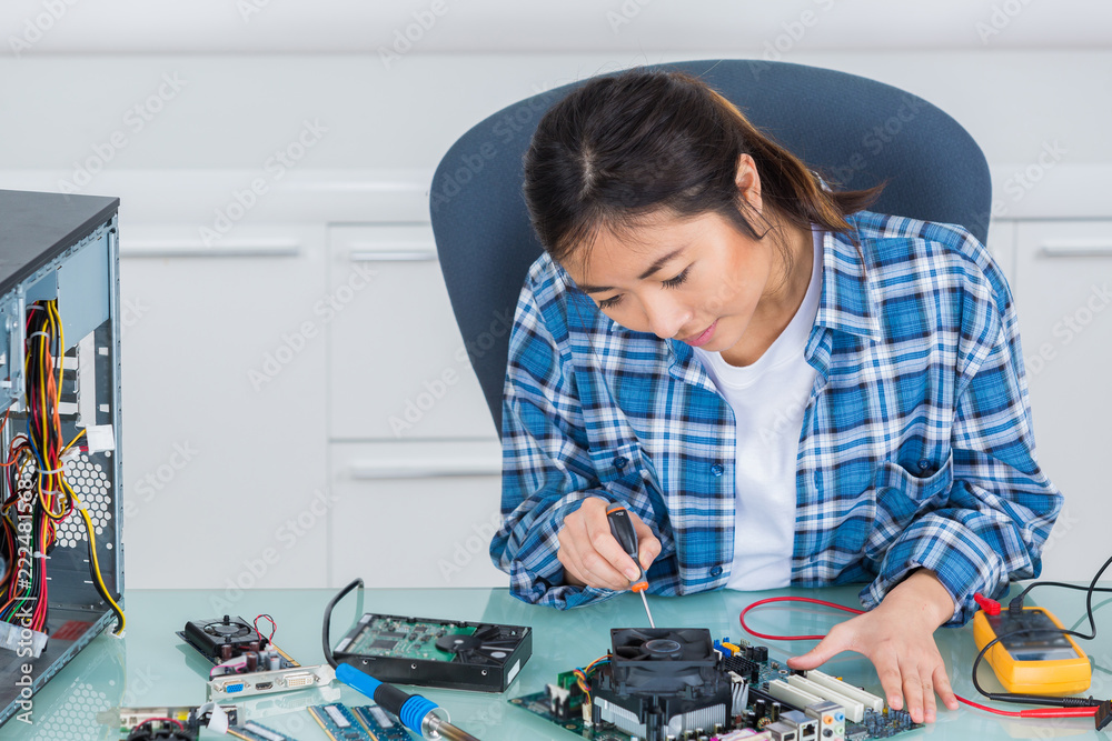 smiling woman fixing computer on a white background smiling woman fixing computer on a white background
