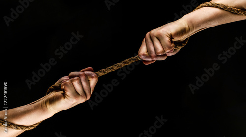 Rescue, help, helping gesture or hands. Conflict, tug of war. Two hands, helping hand, arm, friendship. Teamwork, friendship. Rope, cord. Hand holding a rope, climbing rope, strength and determination