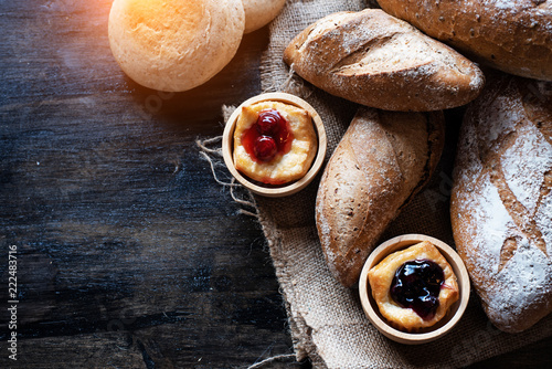 The blueberry pie put beside Baguette berad,on hemp cloth,vintage and art tone,blurry light around photo