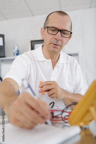 repairman holding glasses busy in his workshop