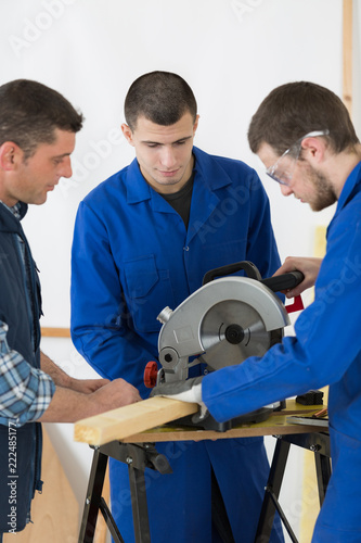 students in carpentry class using circular saw