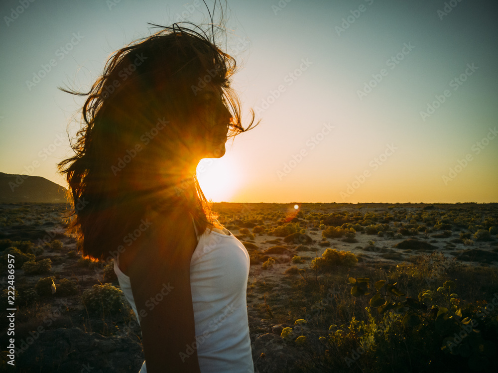 Beatiful carefree young woman with wind in her hair at beach nature. Hipster girl with hairstyle enjoy summer sunset fun. Happy people traveling lifestyle concept. 
