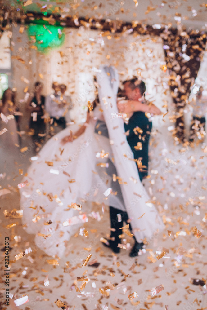First wedding dance of newlywed. Bride and groom dancing around a lot of confetti.