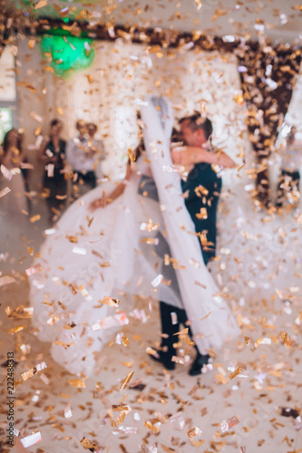 Obraz na płótnie First wedding dance of newlywed. Bride and groom dancing around a lot of confetti. w salonie