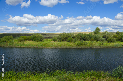 Fototapeta Naklejka Na Ścianę i Meble -  Sunny summer landscape with river,fields,green hills and beautiful clouds in blue sky.River Upa in Tula region,Russia. 