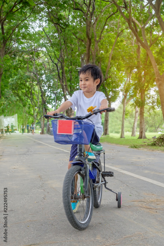 Asian cute boy ride a bicycle at park green nature background Asian cute boy ride a bicycle at park green nature background