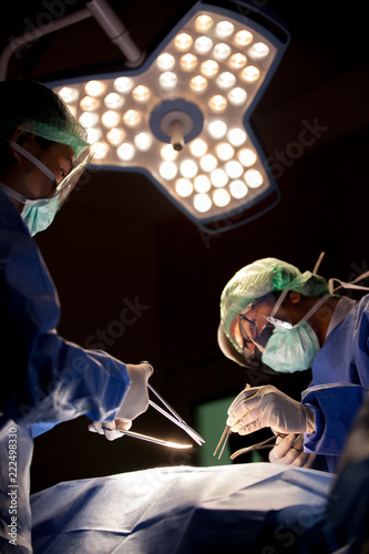 Concentrated doctor, assistant and nurse in a patient during a hysterectomy operation in a hospital