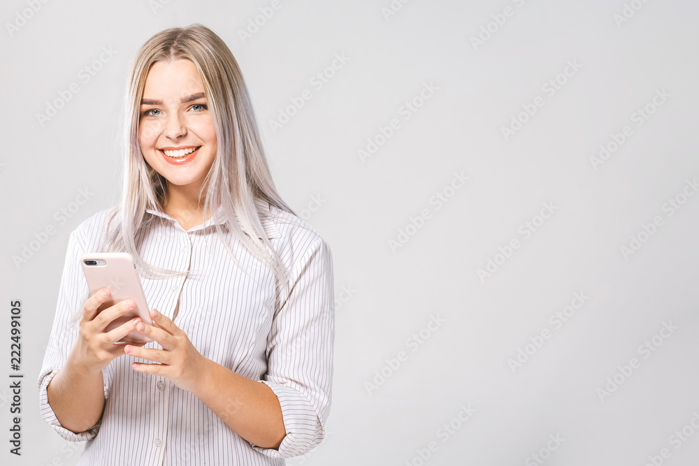 Photo of cheerful cute business beautiful young woman chatting by mobile phone isolated over white wall background. Photo of cheerful cute business beautiful young woman chatting by mobile phone isolated over white wall background.