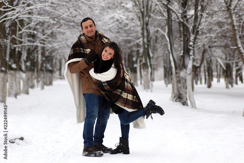 Fototapeta premium A young couple walk in a winter park
