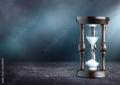Sand running in hourglass on light background