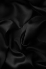 Elegant black satin silk with waves, abstract background.