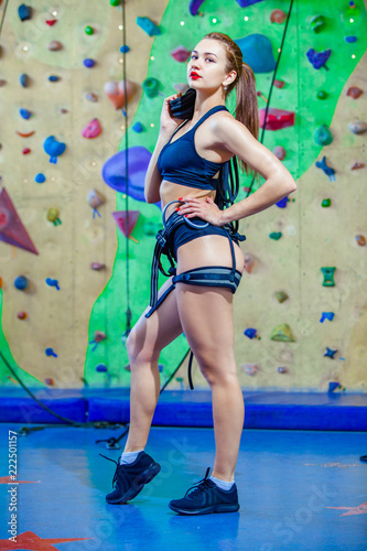 sexual woman climbing on a wall in an outdoor climbing center