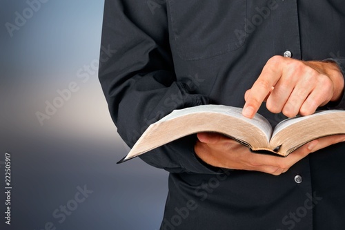 Man reading old heavy book on background