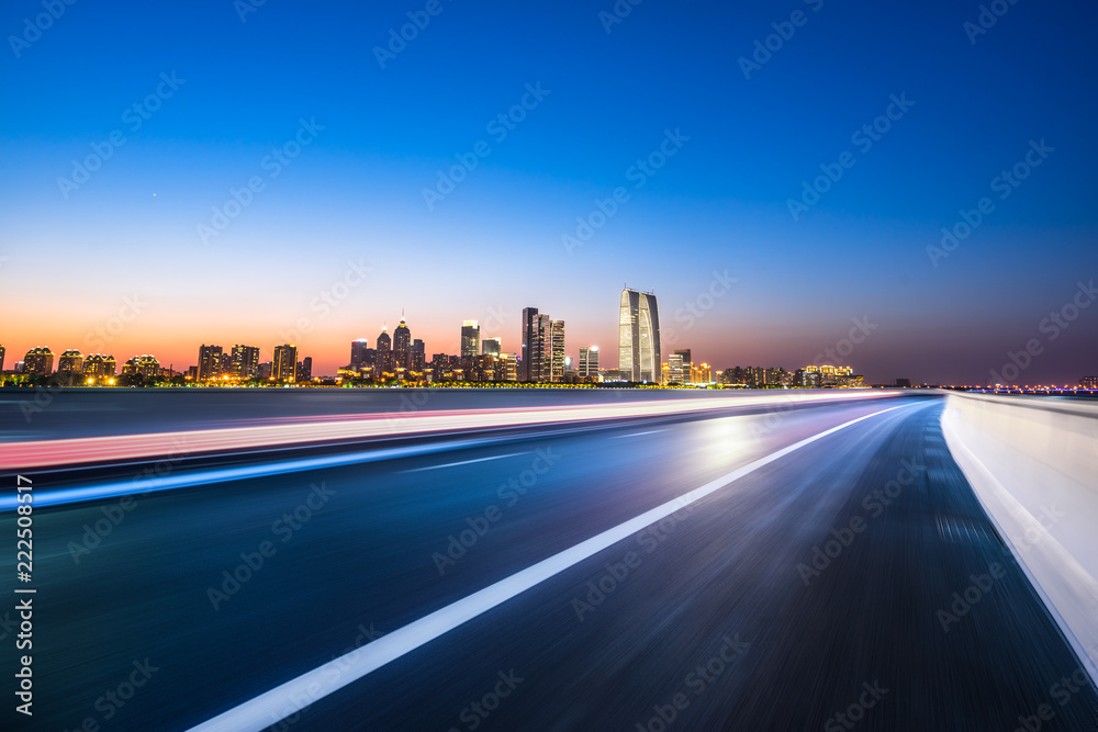 empty asphalt road with city skyline empty asphalt road with city skyline