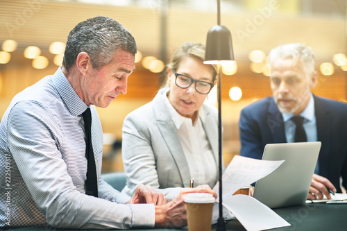 Mature businesspeople going over documents together in an office